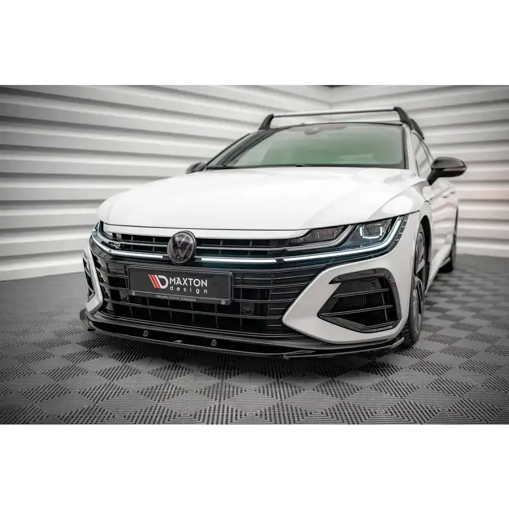 Spoiler på Volkswagen Arteon R med sportslig design, sorte detaljer og moderne LED-lys, sett forfra.