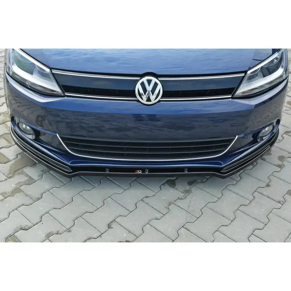 Frontleppe til Volkswagen Jetta Mk6 Sedan, sort spoiler montert under fronten på mørkeblå bil.
