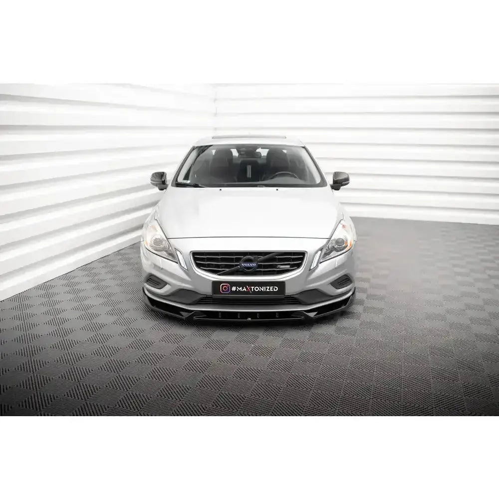 Spoiler på Volvo S60 R-Design Mk2 V.1, sølvfarget bil forfra med sort frontsplitter på rutet gulv.