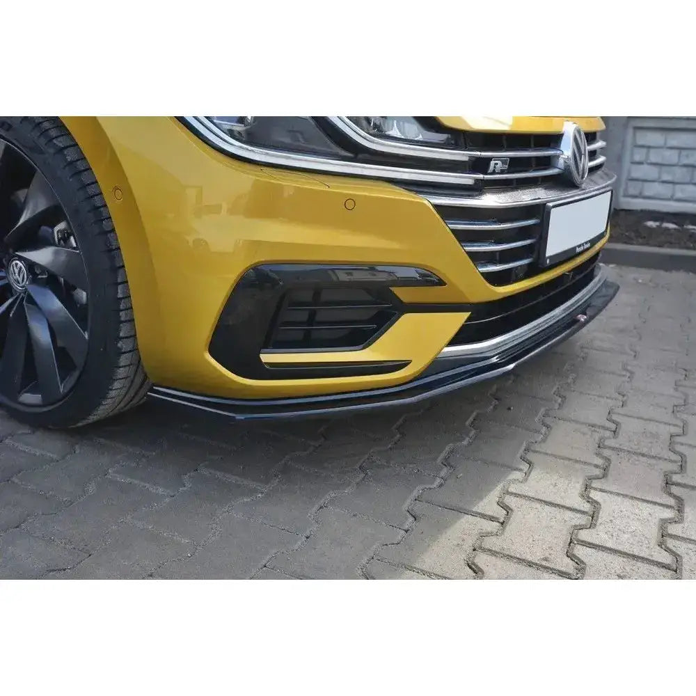 Frontspoiler VW Arteon V.1 i sort, montert på gul bil med skarpe kanter og blanke detaljer, sett forfra.