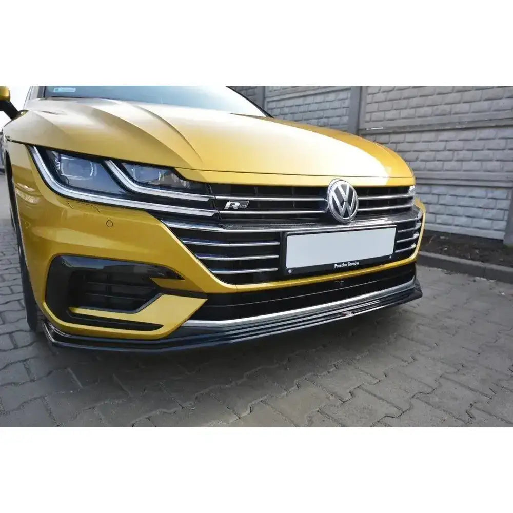 Frontleppe på VW Arteon V.1, gul bil med kromdetaljer, sort spoiler og synlig VW-logo foran.