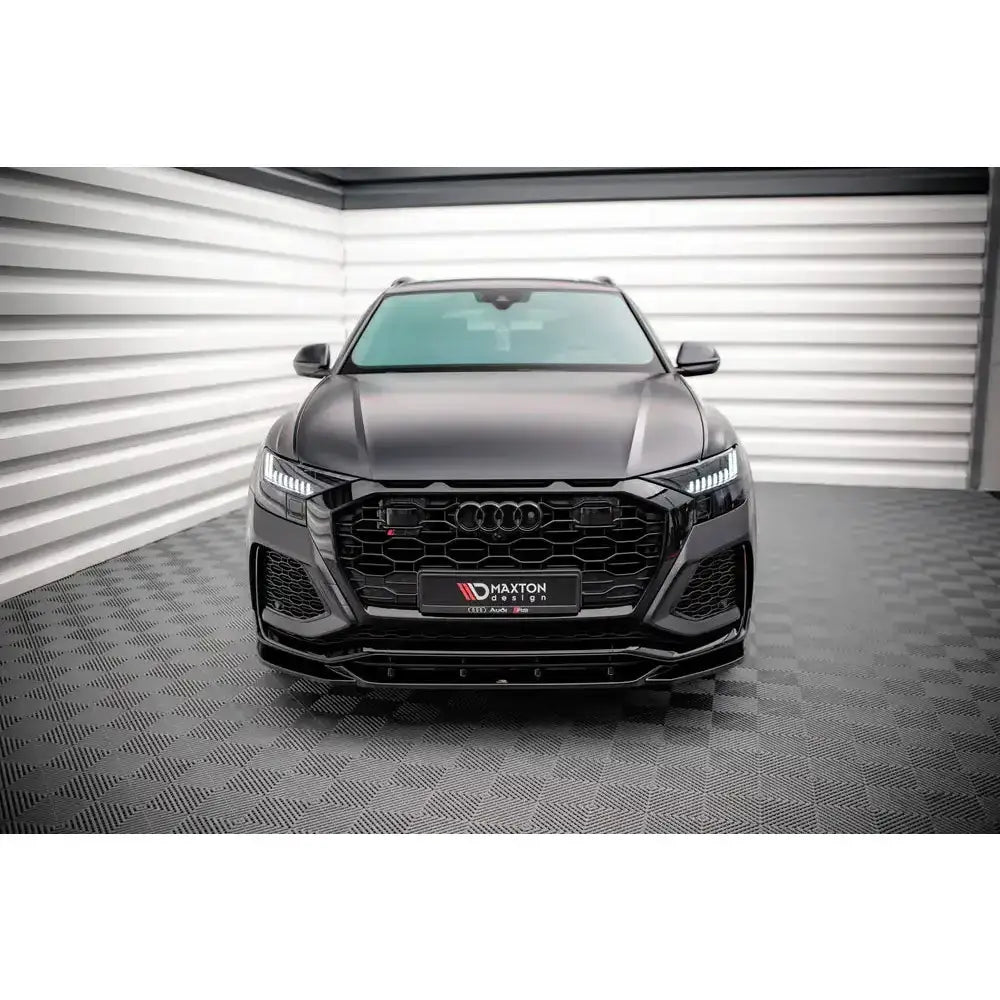 Spoiler på Audi RSQ8 Mk1 V.2, sett forfra med markert grill og LED-lys i lyst industrilokale.