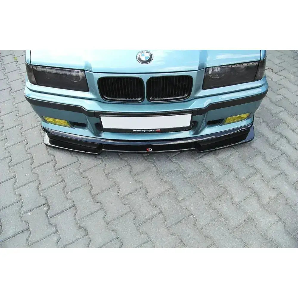 Front splitter BMW M3 E36 V.2 montert på lyseblå bil med gule tåkelys og synlig BMW-logo.