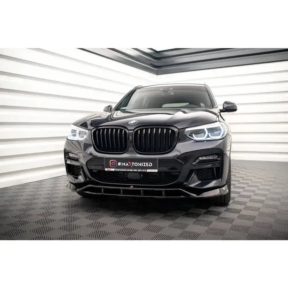 Front splitter på sort BMW X3 M40d med LED-lykter og stor svart grill sett rett forfra.
