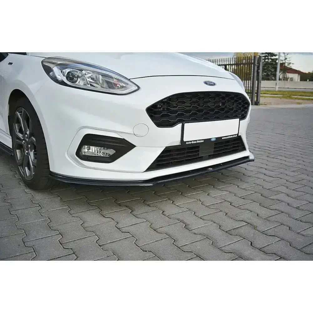 Frontleppe på hvit Ford Fiesta Mk8 ST st-Line V.2 med svart spoiler og grill, parkert på belegningsstein.