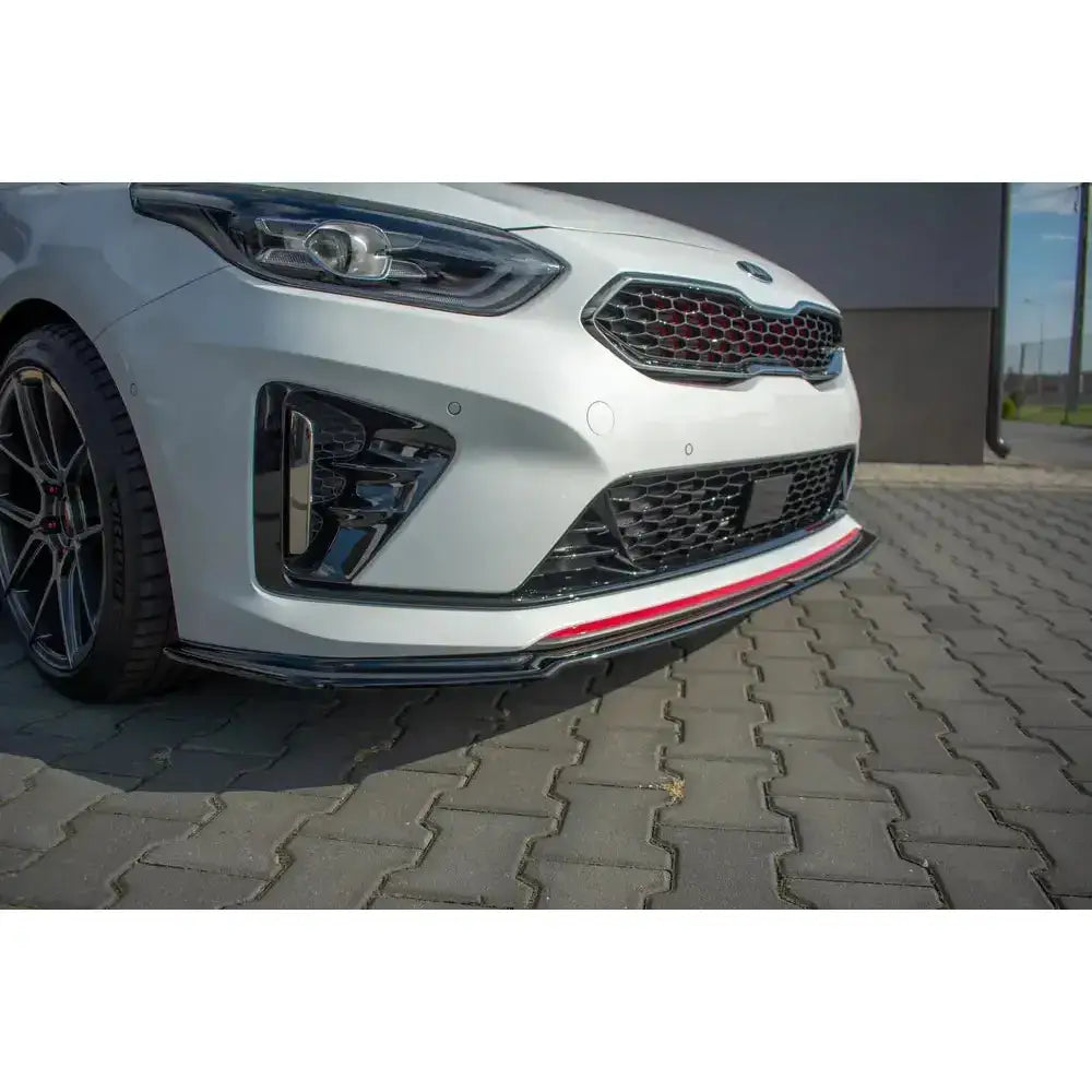Front lip på Kia Proceed GT Mk 3 V.2 med sort og rød spoilerlist, bikakemønstret grill og felg med røde detaljer.