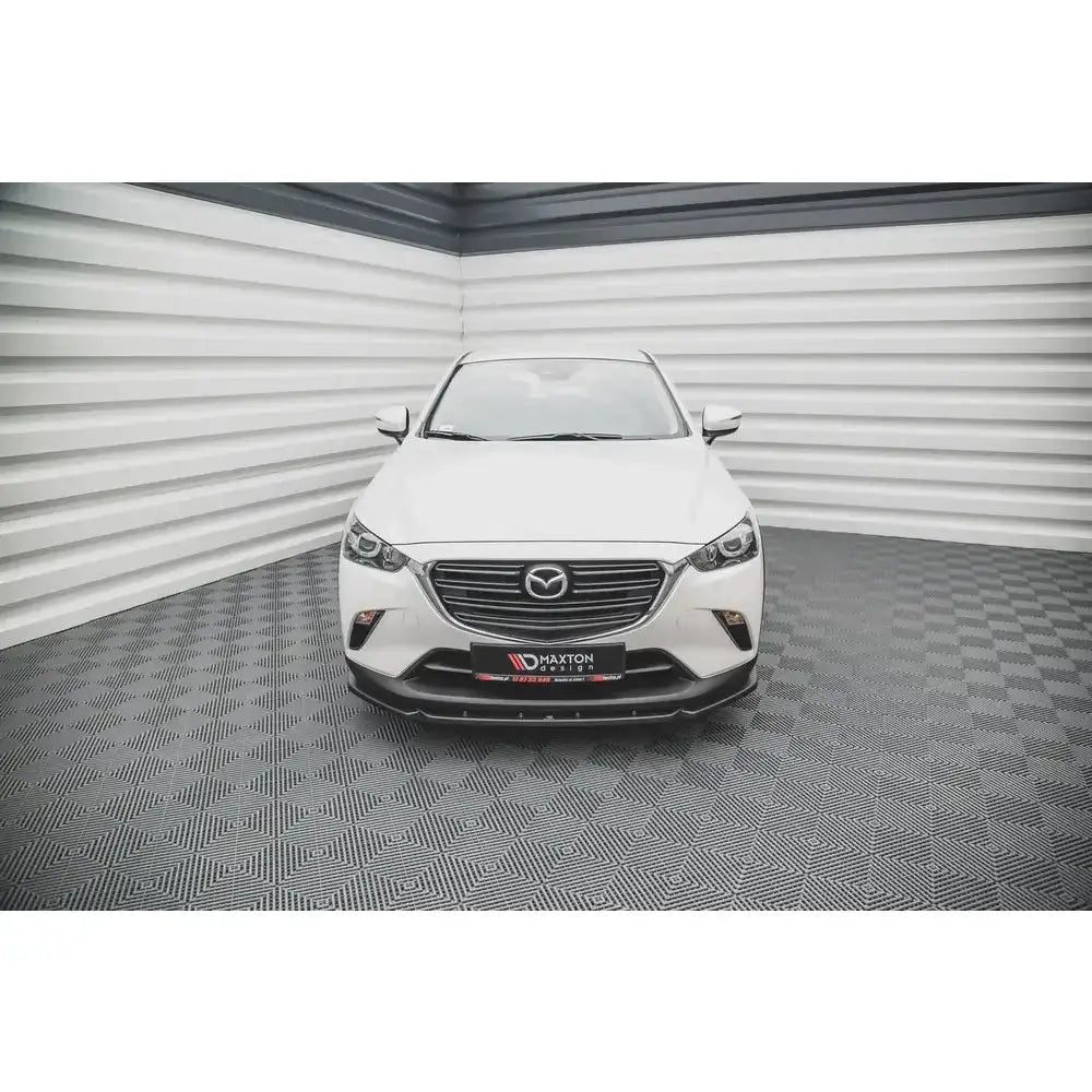 Spoiler til Mazda CX-3 V.2 15-, sort frontspoiler montert på hvit bil sett forfra i lyst rom.
