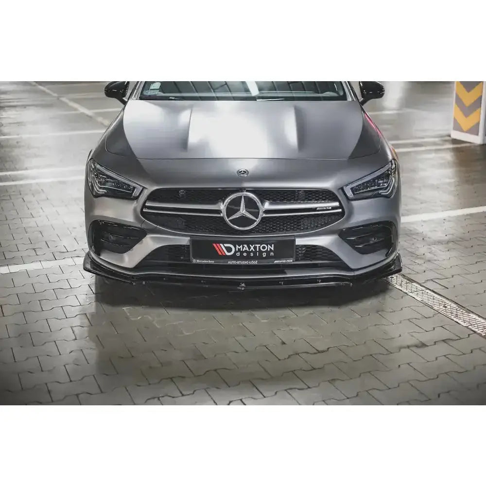 Spoiler til Mercedes CLA 35 V.2 Aero C118 montert foran på sølvfarget bil med Maxton Design-logo.