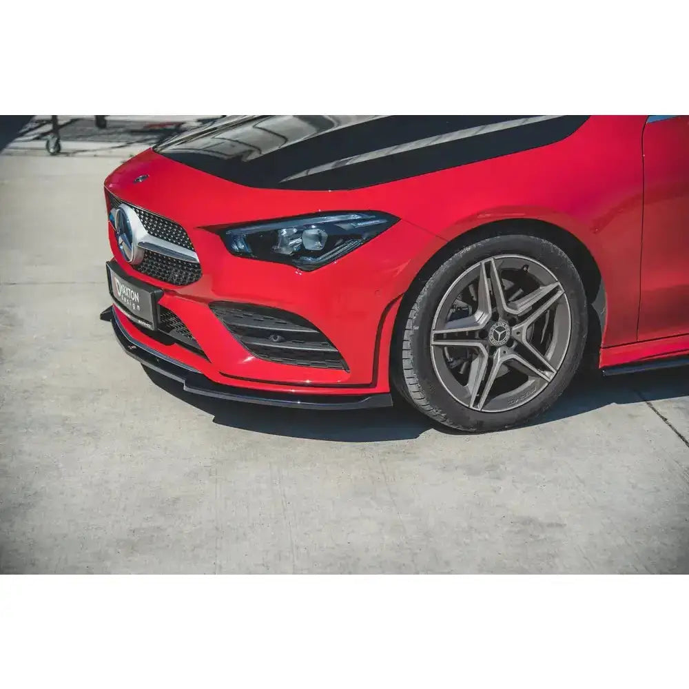 Front splitter på rød Mercedes CLA C118 V.2 Amg-Line med svarte detaljer og sølvfelger i sollys.