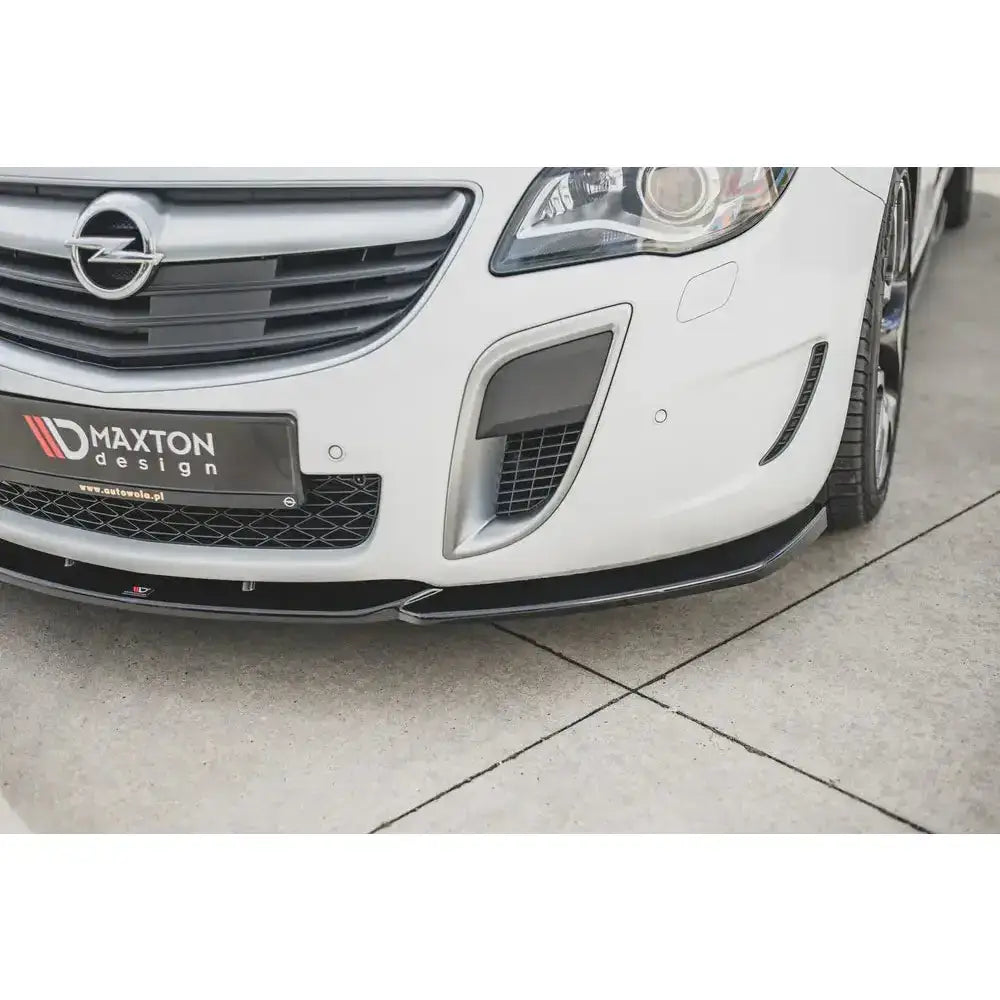Spoiler til Opel Insignia MK. 1 OPC Facelift, nærbilde av svart frontsplitter på hvit bil med Maxton Design-skilt.