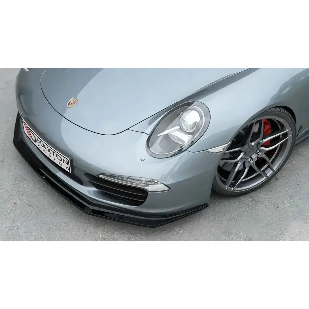 Front splitter på Porsche 911 Carrera 991 V.2 med svart spoiler, røde bremsecalipere og aluminiumsfelger.