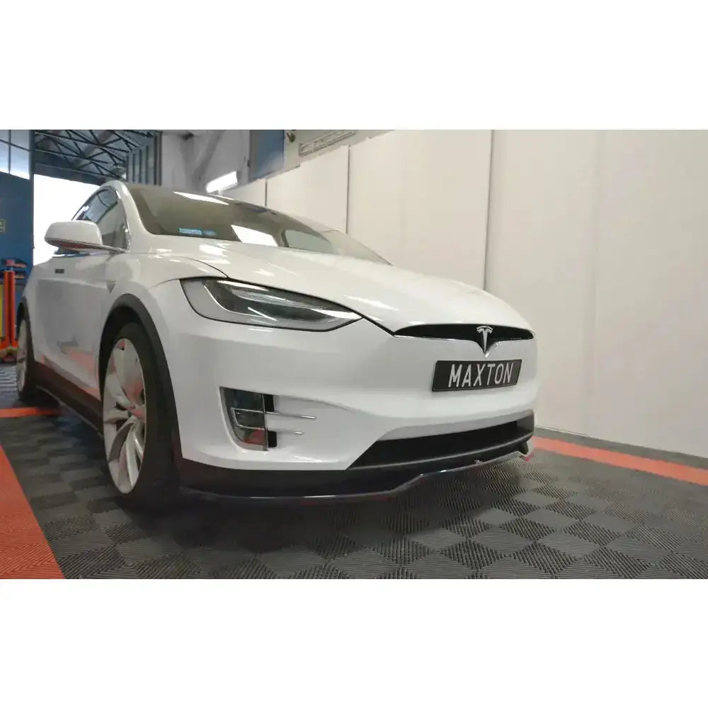 Frontleppe til Tesla Model X V.2 montert på hvit bil, sett forfra i lav vinkel innendørs.