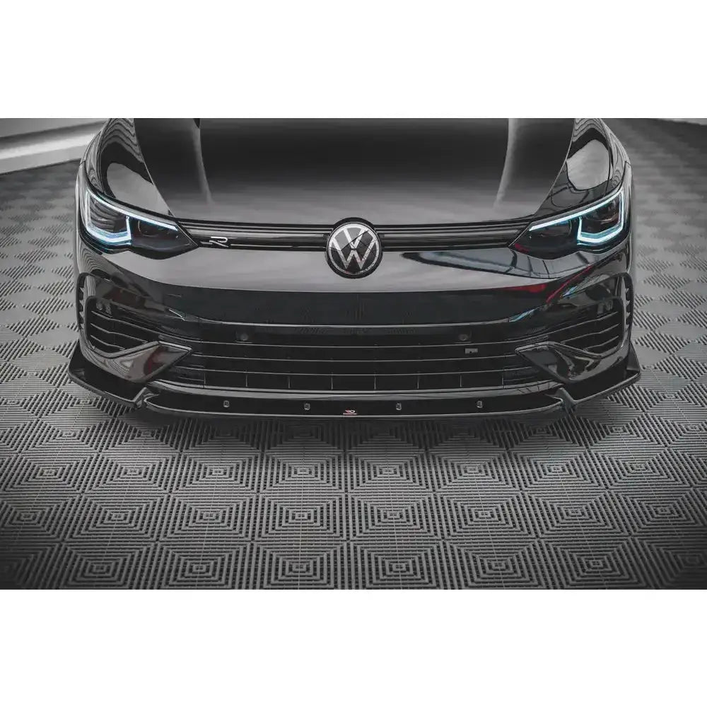Spoiler til Volkswagen Golf R Mk8 V.2, sort front med LED-lykter og krom, sett rett forfra.