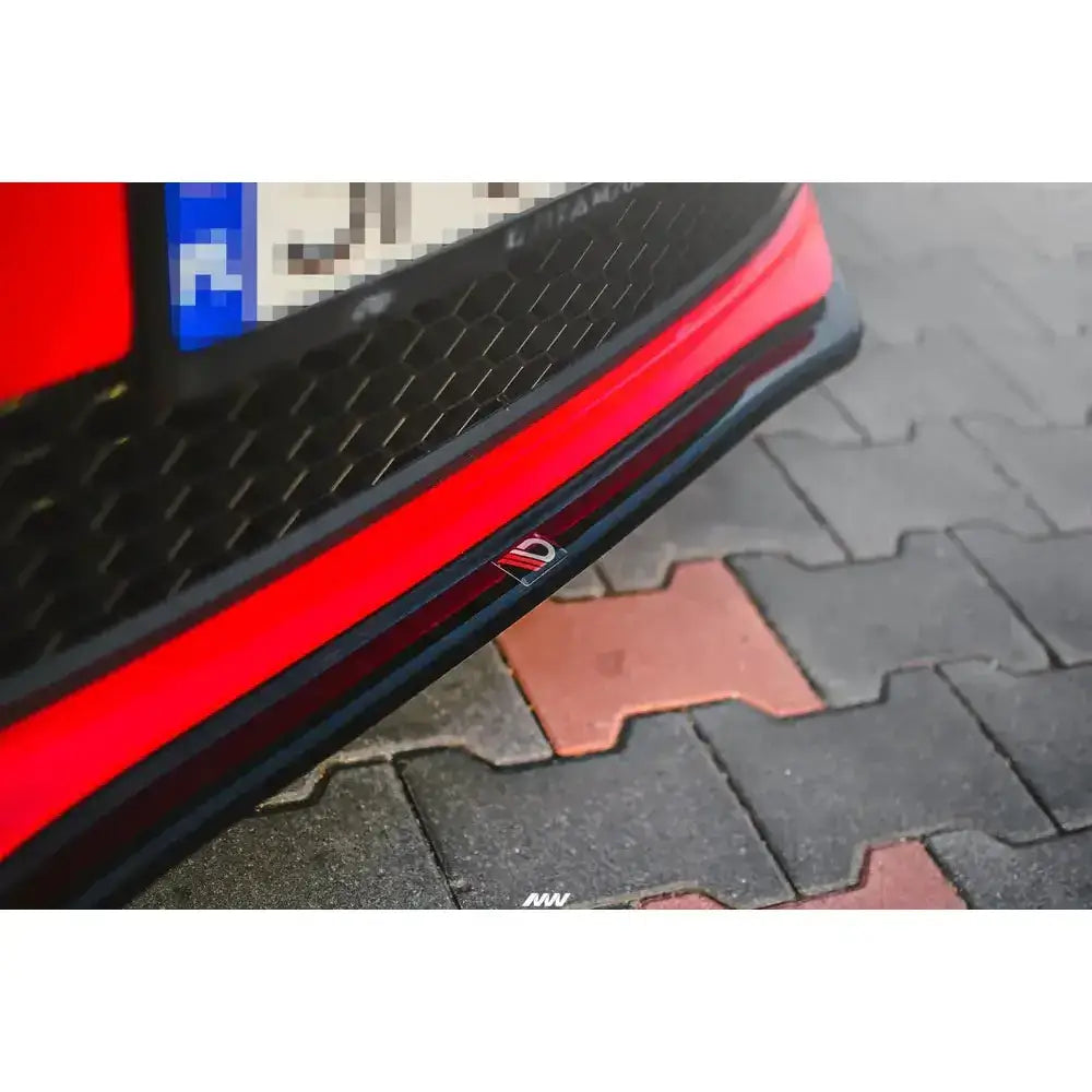 Spoiler til Volkswagen Polo Mk5 Gti 6R V.2, rød og svart, sett nedenfra mot bilgrill og belegningsstein.