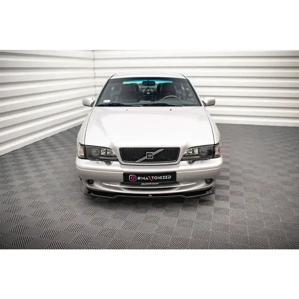 Spoiler på Volvo C70 Mk1 V.3 sett forfra, sølvfarget bil med mørk grill på grått gulv.