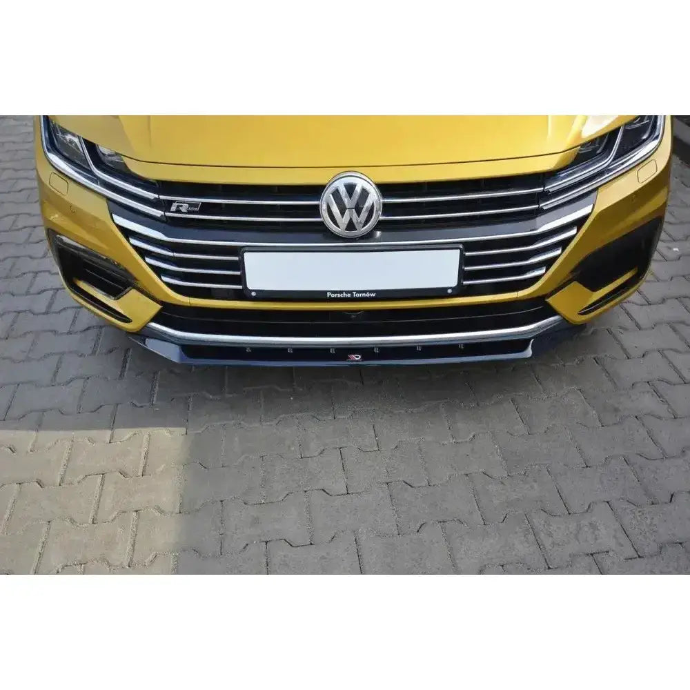Frontspoiler VW Arteon V.2 montert på gul bil med kromdetaljer, sett rett forfra.