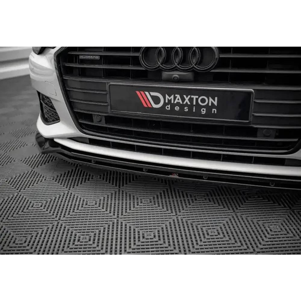 Spoiler til Audi A6 C8 V.3 montert foran på hvit bil med sort grill, sett fra lav vinkel.