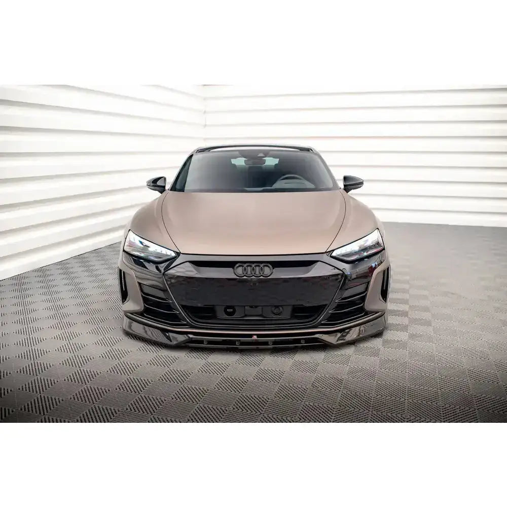 Frontspoiler på Audi e-Tron GT Mk1 med svarte detaljer, sett rett forfra innendørs.