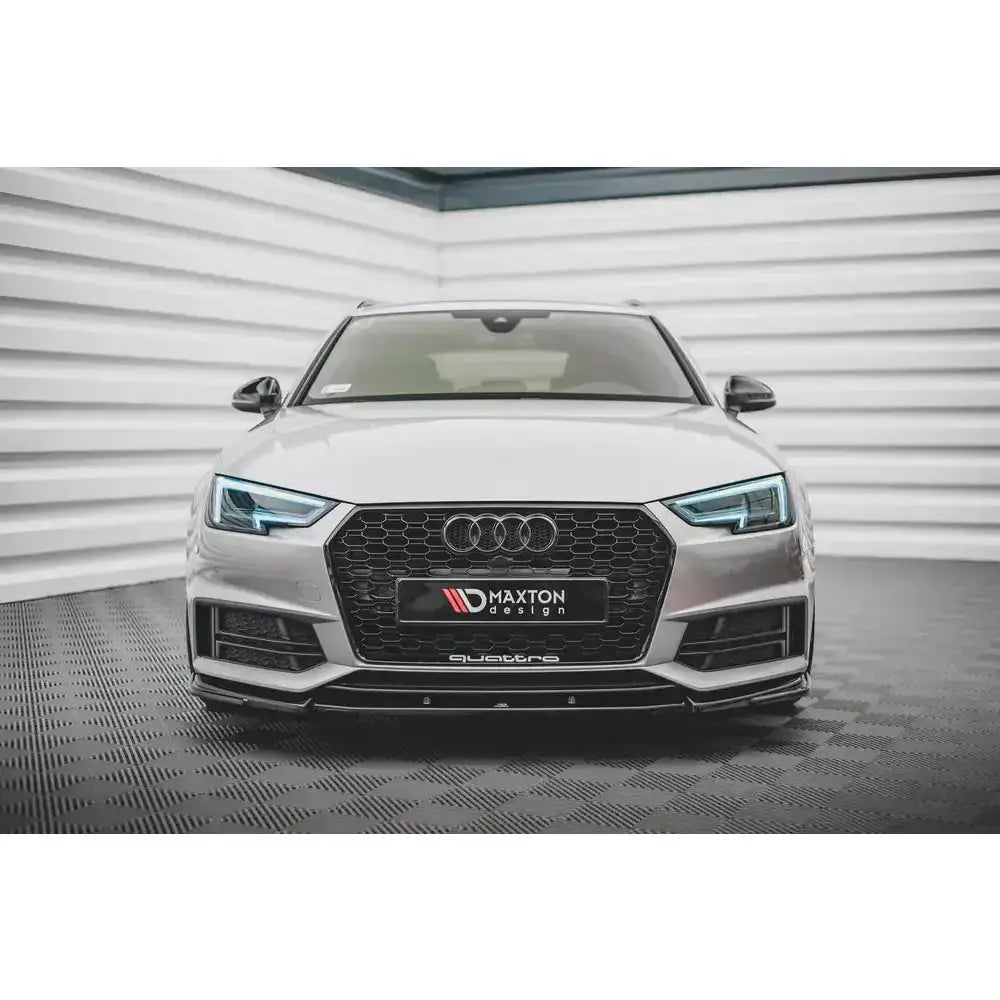 Spoiler på Audi S4 B9 med svart grill og blå LED-lykter, sett forfra i lyst rom.