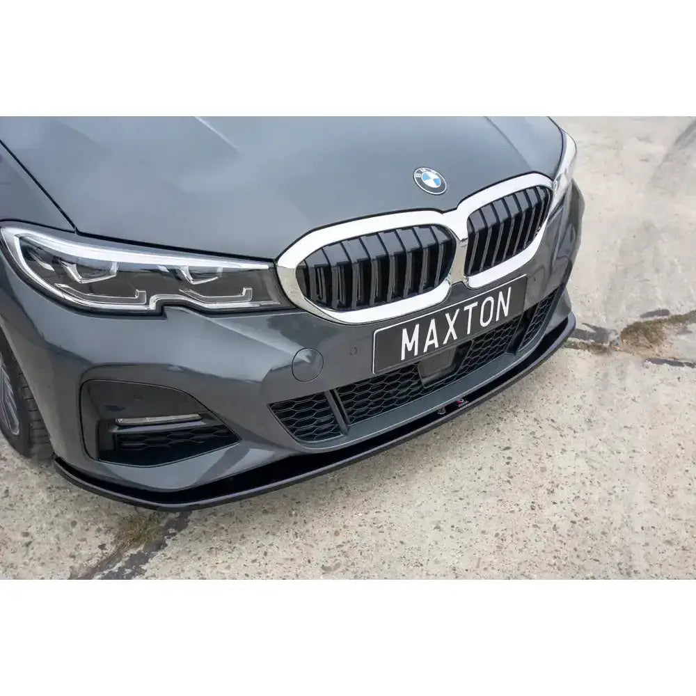 Spoiler til BMW 3 G20 M-Pack V.3, nærbilde av sort frontsplitter og Maxton-logo på grå bil.