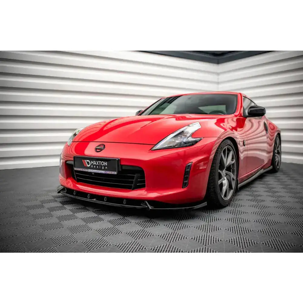 Frontleppe på Nissan 370Z Facelift 12-20 V.3, rød bil med mørke felger sett skrått forfra innendørs.