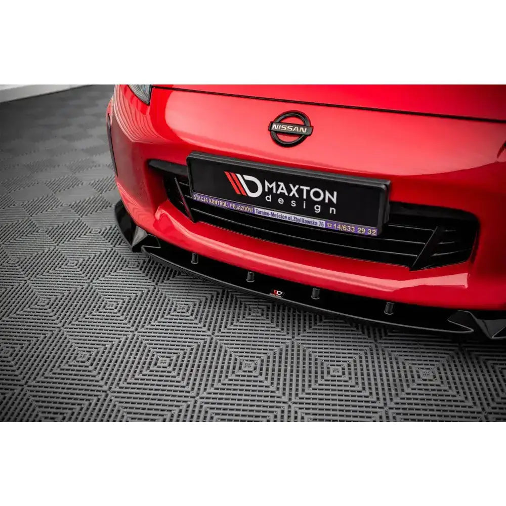 Front splitter på Nissan 370Z Facelift med sort plastmontering under rød støtfanger, sett forfra.