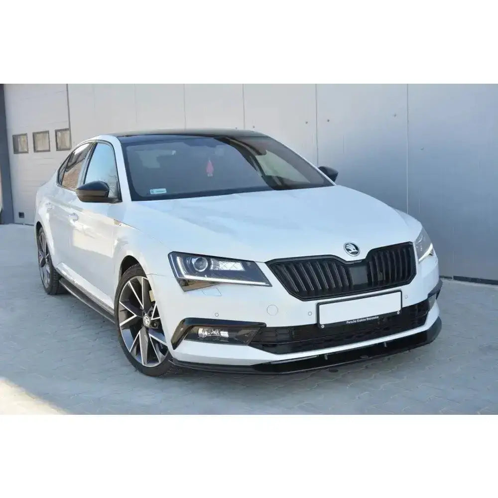 Frontleppe på Skoda Superb III V.3 med sorte detaljer på grill, speil og felger, sett skrått forfra.
