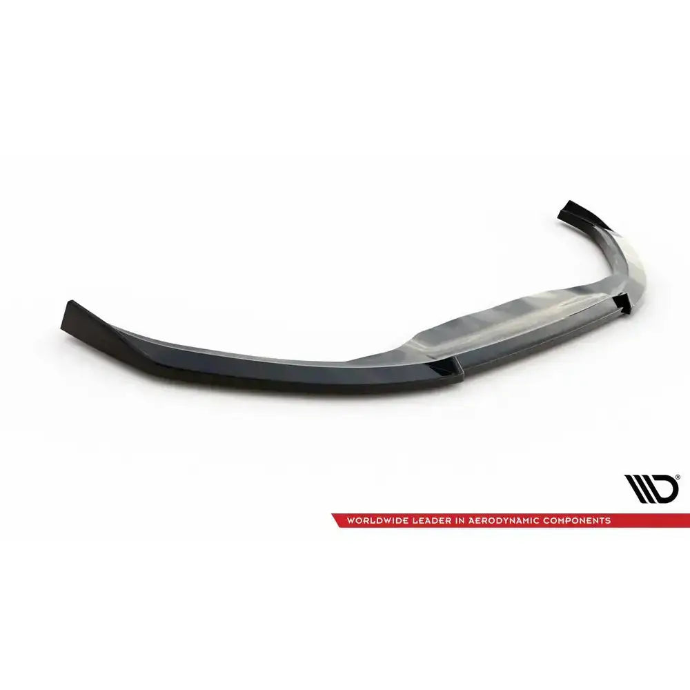 Front lip til Toyota Yaris Mk4 V.3, svart buet spoiler med blank finish, sett skrått mot hvit bakgrunn.