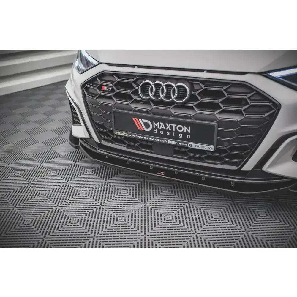 Front lip på hvit Audi S3 med sort bikubemønstret grill og Maxton Design-logo, sett fra lav vinkel.