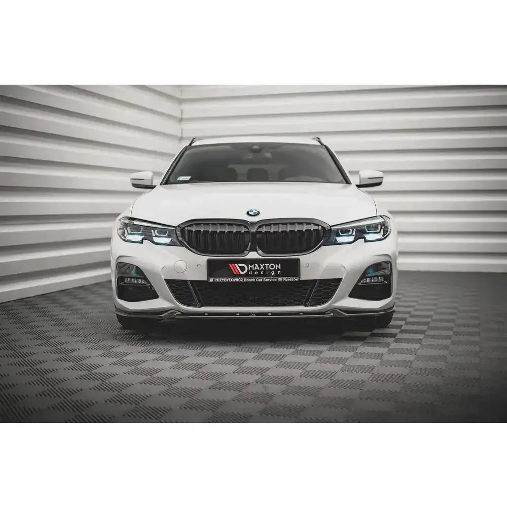 Frontspoiler på BMW 3 G20/G21 M-Pack med sorte grilldetaljer og LED-frontlykter, sett forfra.