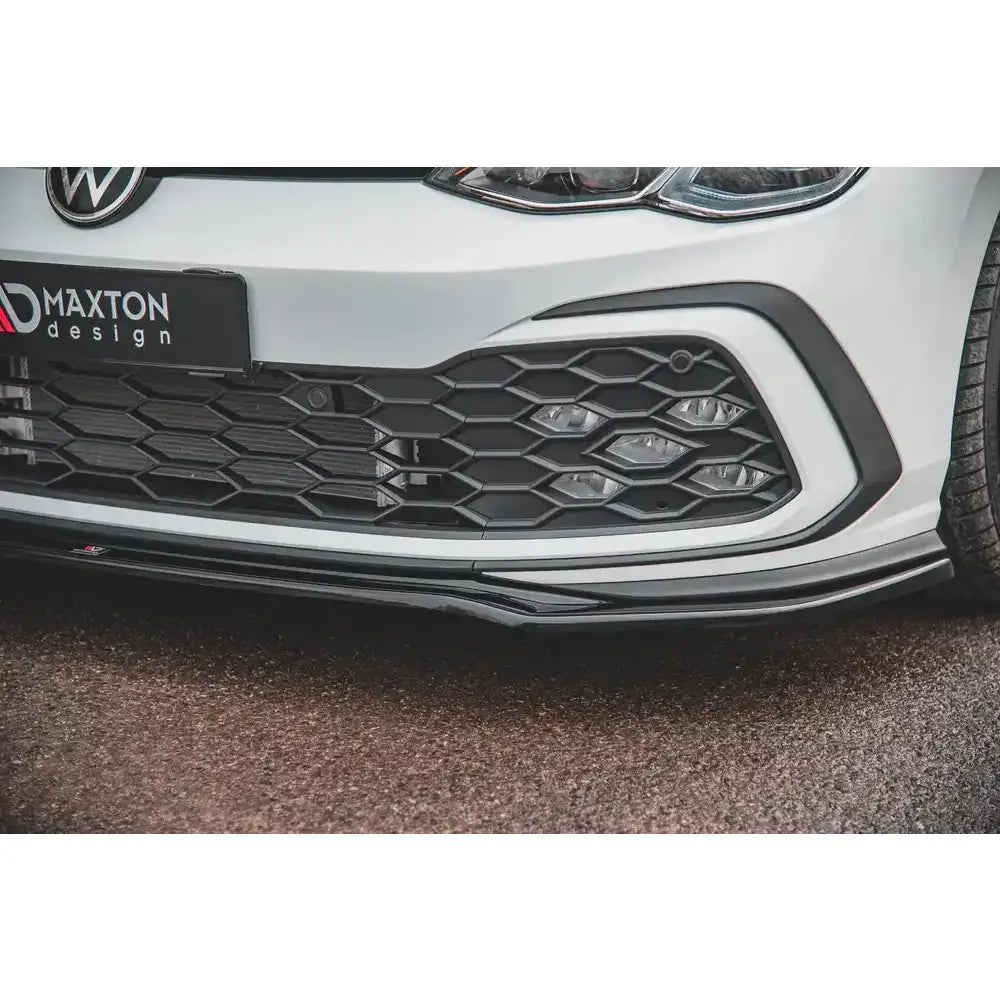 Frontspoiler Volkswagen Golf 8 GTI V.4, sort plast med bikakemønstret grill på hvit bil.