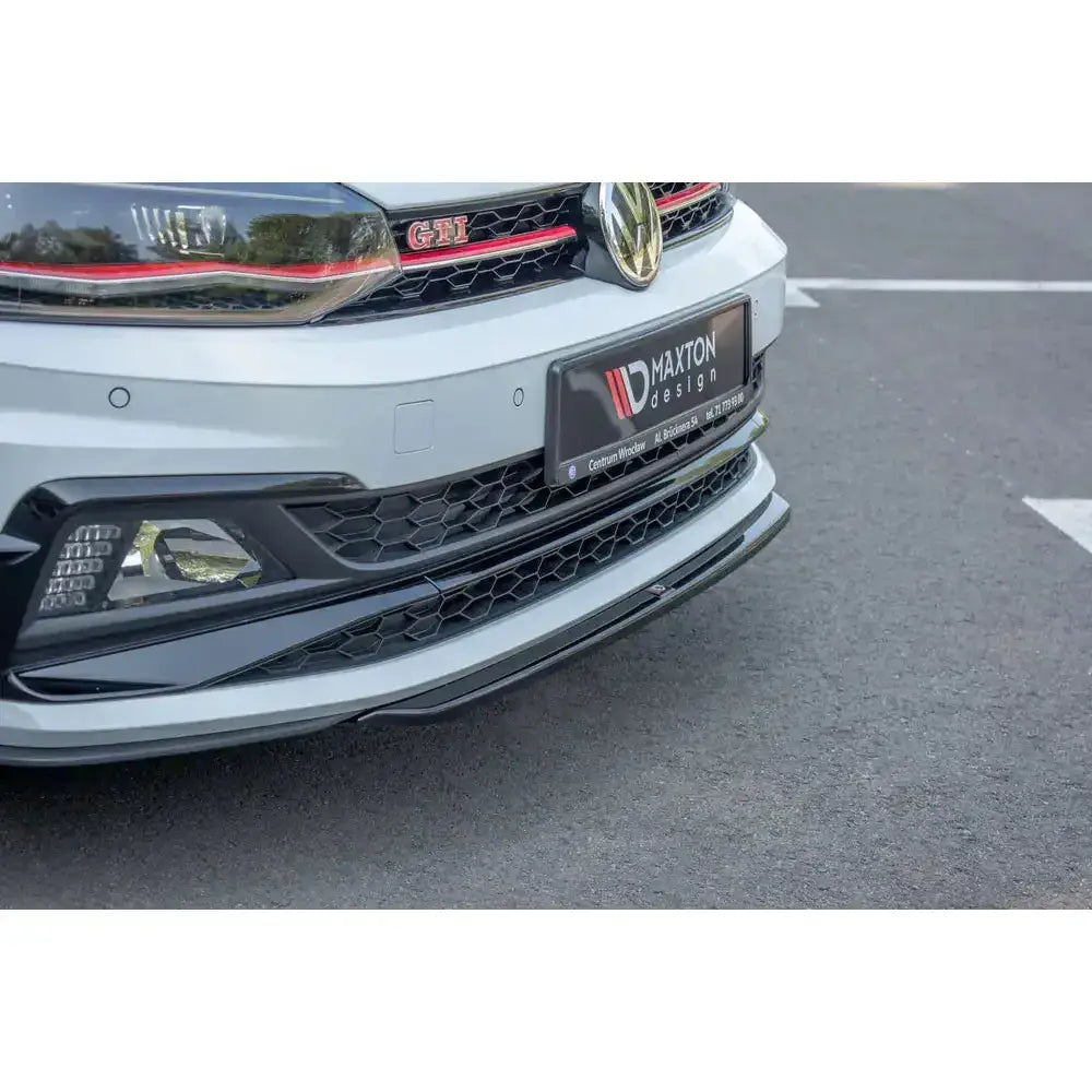 Spoiler til VW Polo GTI MK6 V.4 i blank plast med røde detaljer, sett skrått forfra på hvit bil.