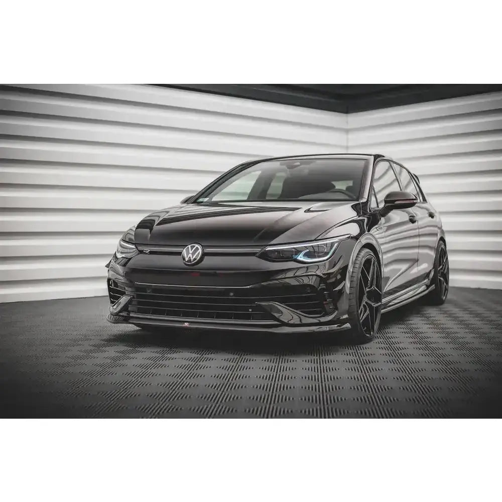 Spoiler på Volkswagen Golf R Mk8 V.5 sett forfra med sorte felger og LED-frontlykter innendørs.