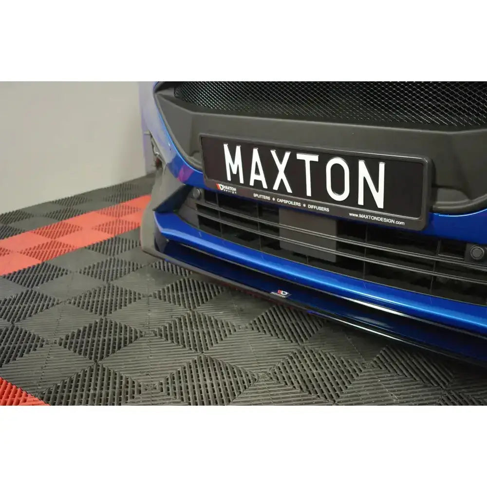 Spoiler til Ford Focus ST MK4 V.6 vist foran på blå bil med sort frontsplitter og rutete gulv.