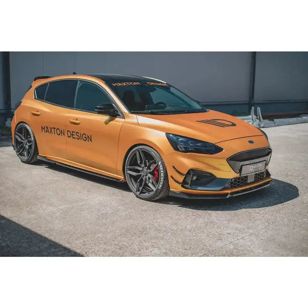 Frontleppe på oransje Ford Focus ST med svarte detaljer, store felger og Maxton Design-logo.