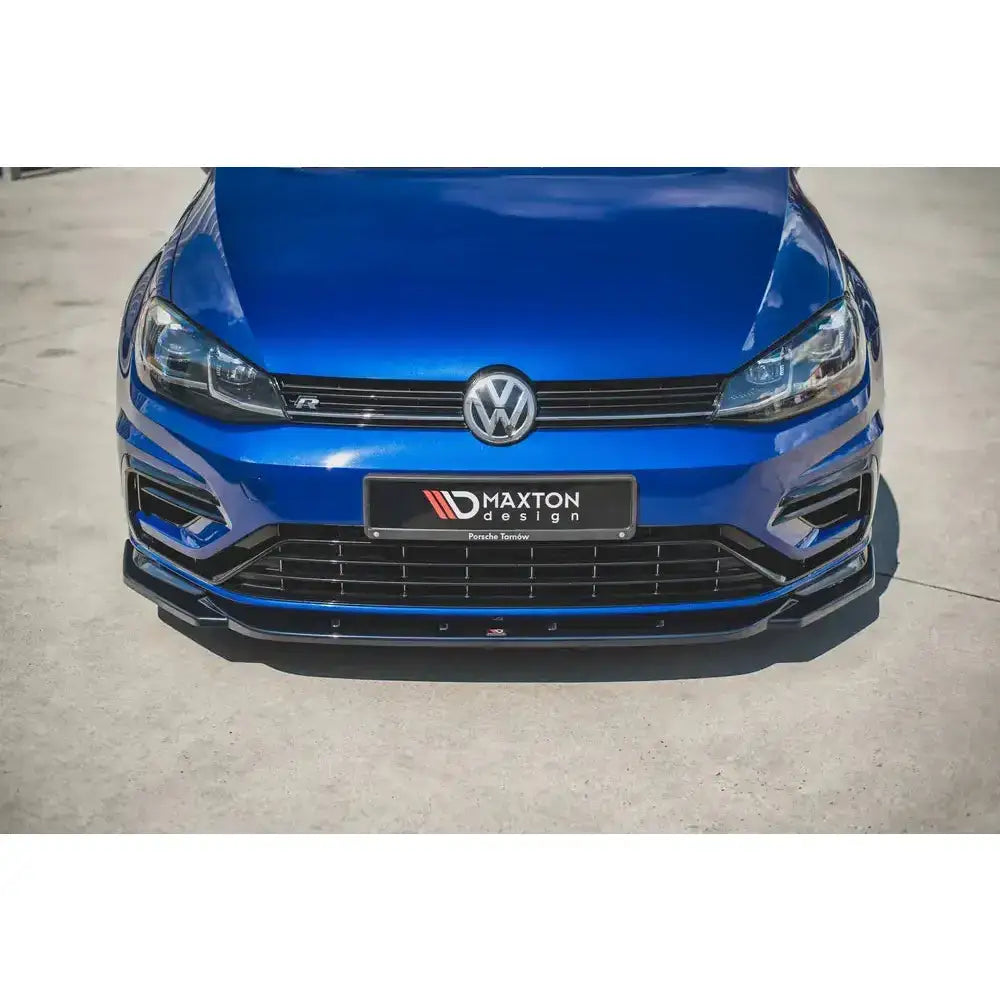 Spoiler til VW Golf 7 R Facelift V.9 montert under støtfanger på blå bil, sett forfra utendørs.