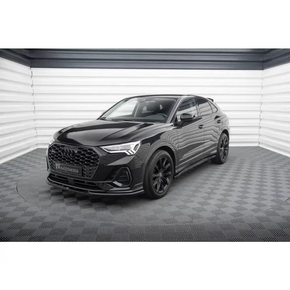 Frontleppe på Audi Q3 Sportback F3 V.1, svart SUV med sorte felger og markant frontgrill innendørs.