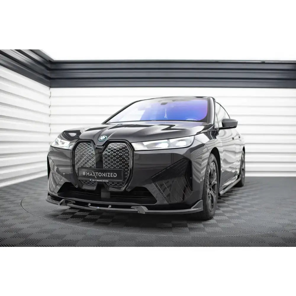 Frontleppe på BMW iX M-Pack i20 V.1, svart bil med store grilldetaljer på rutete gulv.