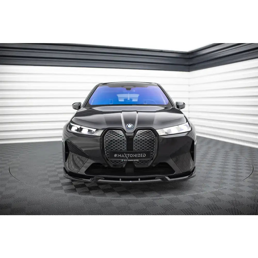 Spoiler på BMW iX M-Pack i20 V.1 sett forfra med markant grill og blåtonet frontrute.