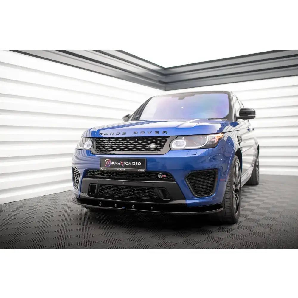 Frontspoiler på blå Range Rover Sport SVR Mk2 med svarte detaljer og LED-frontlykter innendørs.