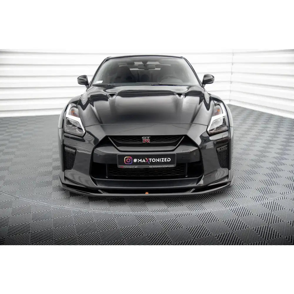 Spoiler på Nissan GTR R35 Facelift V.1 sett forfra med markant grill og lave linjer på grått gulv.