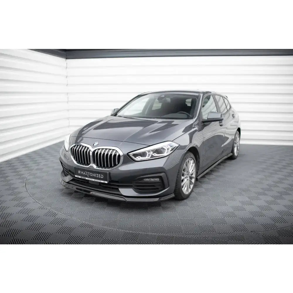 Spoiler BMW 1 F40 V.2 montert på mørk grå bil sett skrått forfra med synlig frontgrill og felger.