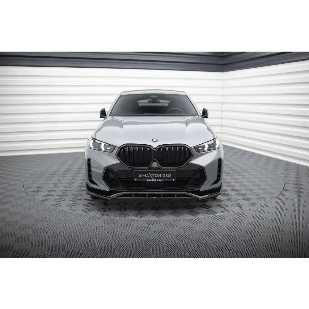 Frontleppe på BMW X6 M-Pack G06 Facelift V.2 med sorte grilldetaljer, sett forfra i lyst rom.