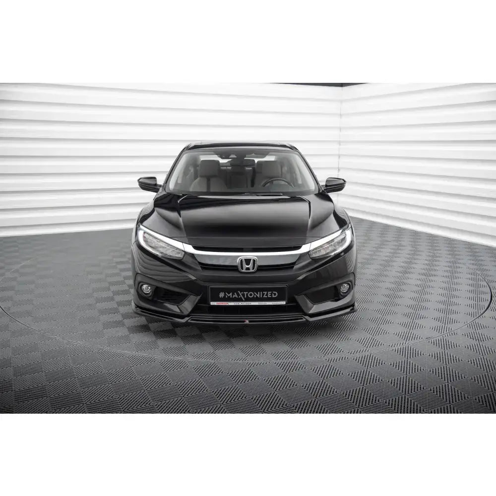 Frontleppe Honda Civic Mk10 V.2 montert på svart bil med kromdetaljer og LED-lys i lyst rom.
