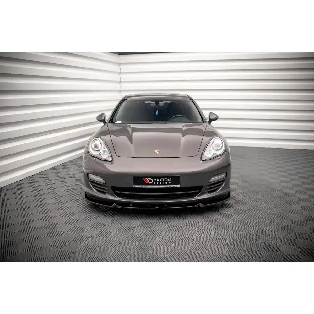 Frontspoiler på Porsche Panamera 970, sort farge montert under frontlyktene, innendørs.