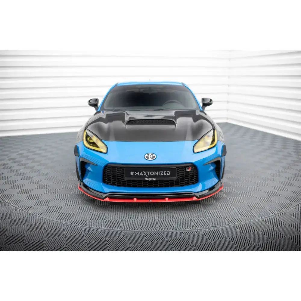 Front splitter på Toyota GR86 Mk1 V.3 med sort panser, gule lykter og røde detaljer, sett forfra.