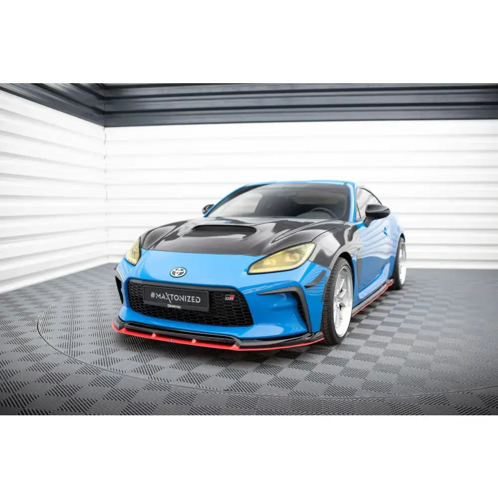 Front lip på Toyota GR86 Mk1 V.3 i blått med rød spoilerlip, gule lykter og hvite felger innendørs.