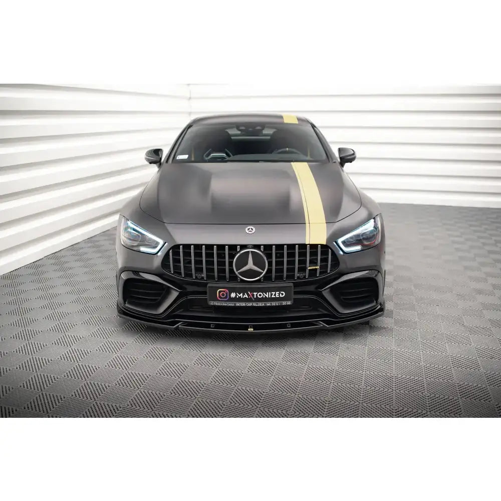 Frontleppe på Mercedes GT 63S 4-Door Coupe V.3 Aero med gul stripe, sett rett forfra innendørs.