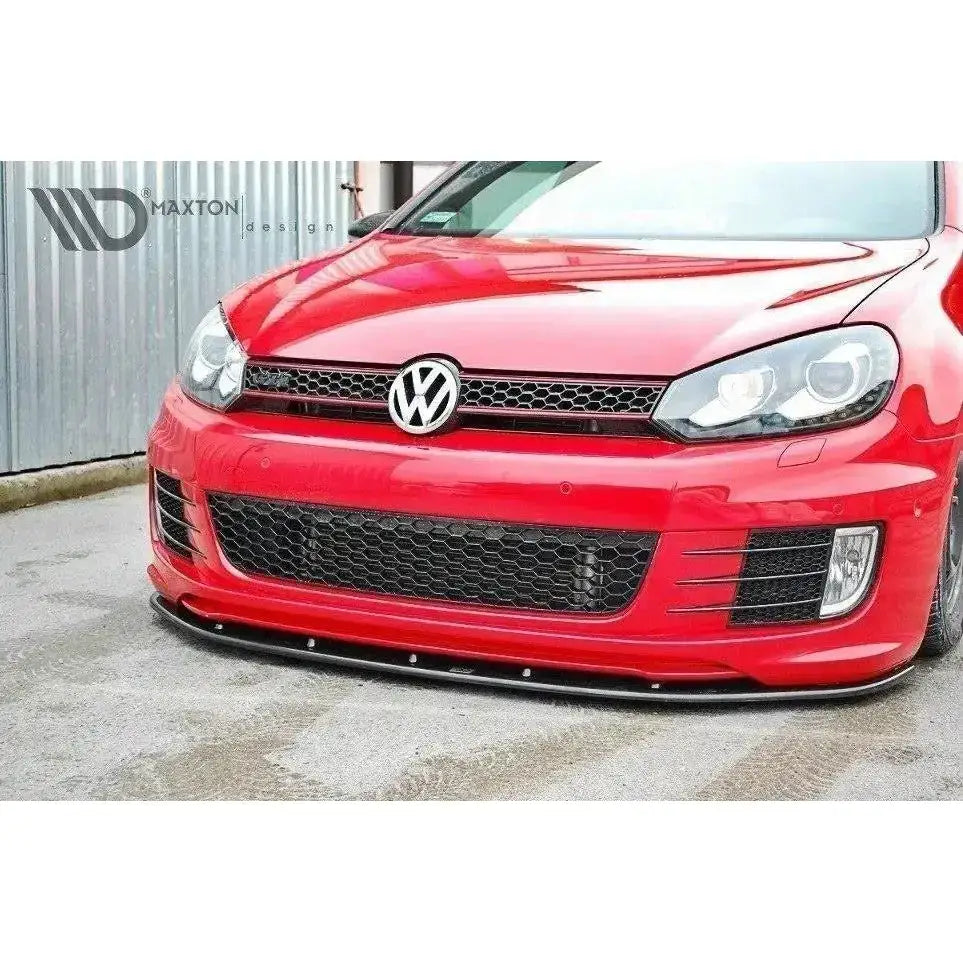 Spoiler til VW Golf VI GTI 35th, nærbilde av sort frontsplitter på rød bil med svart grill.