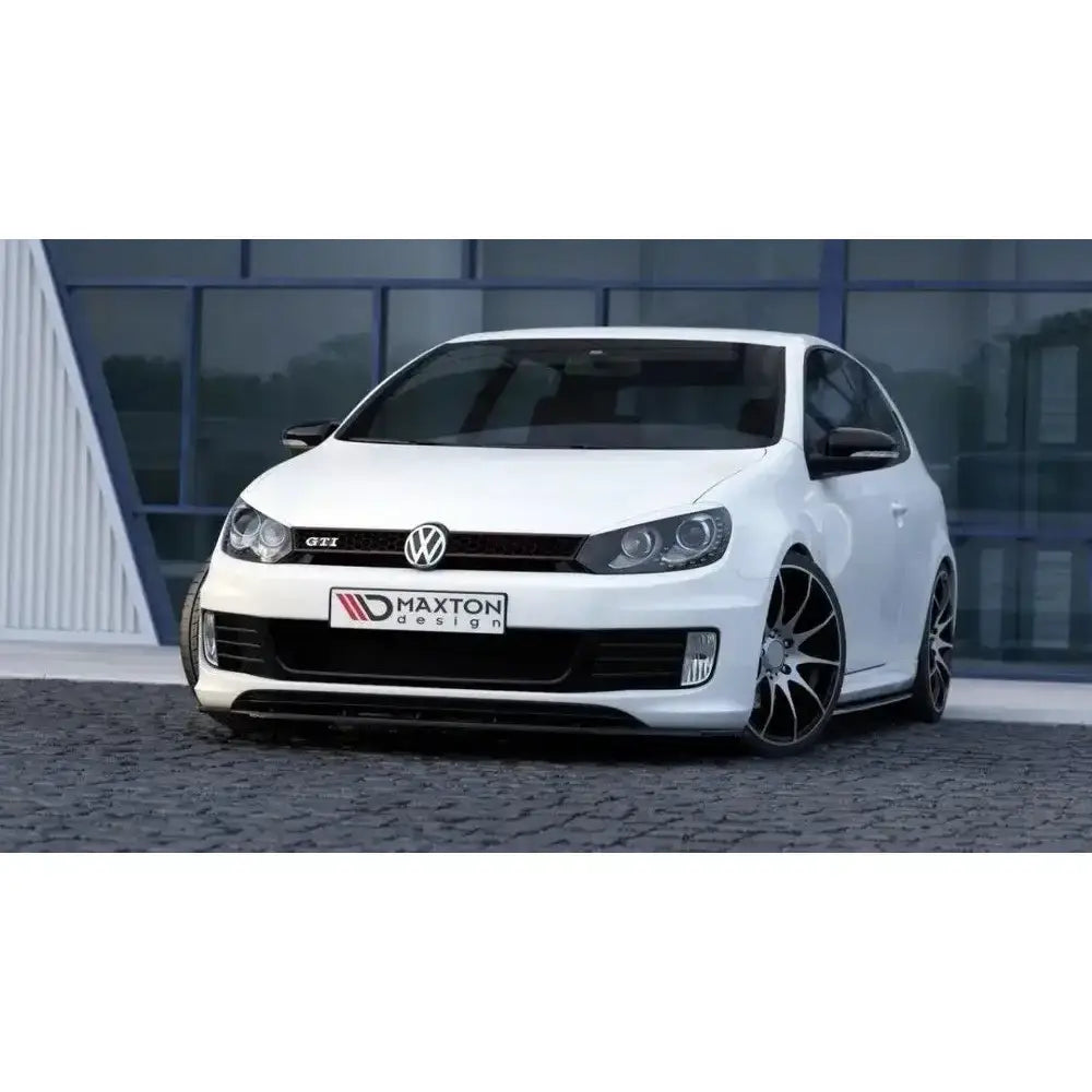 Front splitter på VW Golf VI GTI 35th med sorte felger, lav frontspoiler og bygning i bakgrunnen.